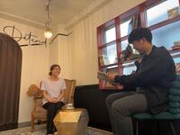 　取材を受けるデタンデュ・川岸さん（左）