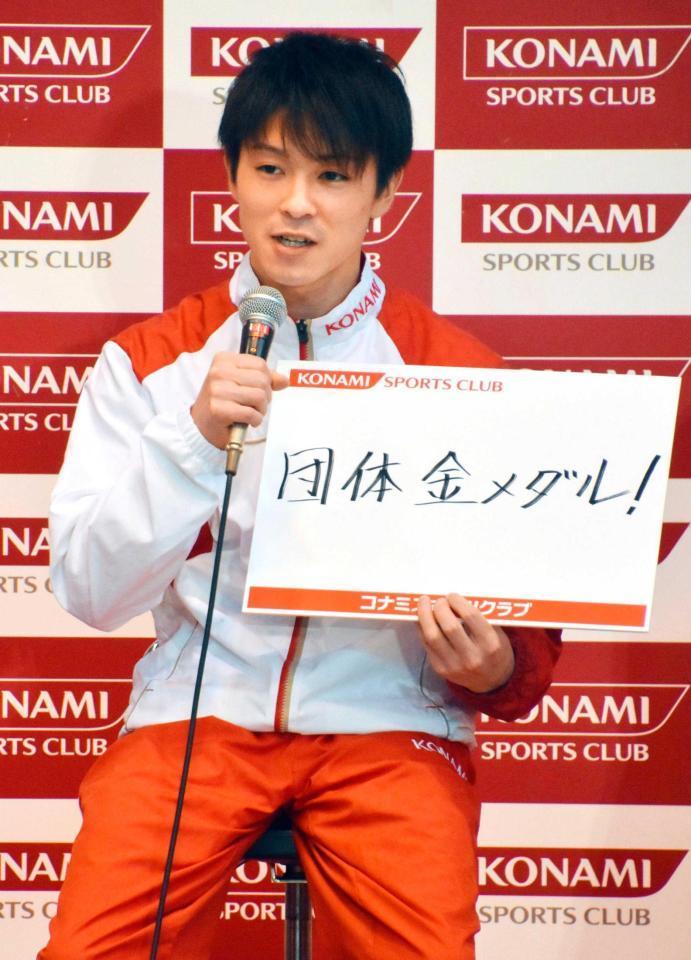 　コナミスポーツのリオ五輪壮行会で、団体金メダルと書いたパネルを見せる内村航平（共同）