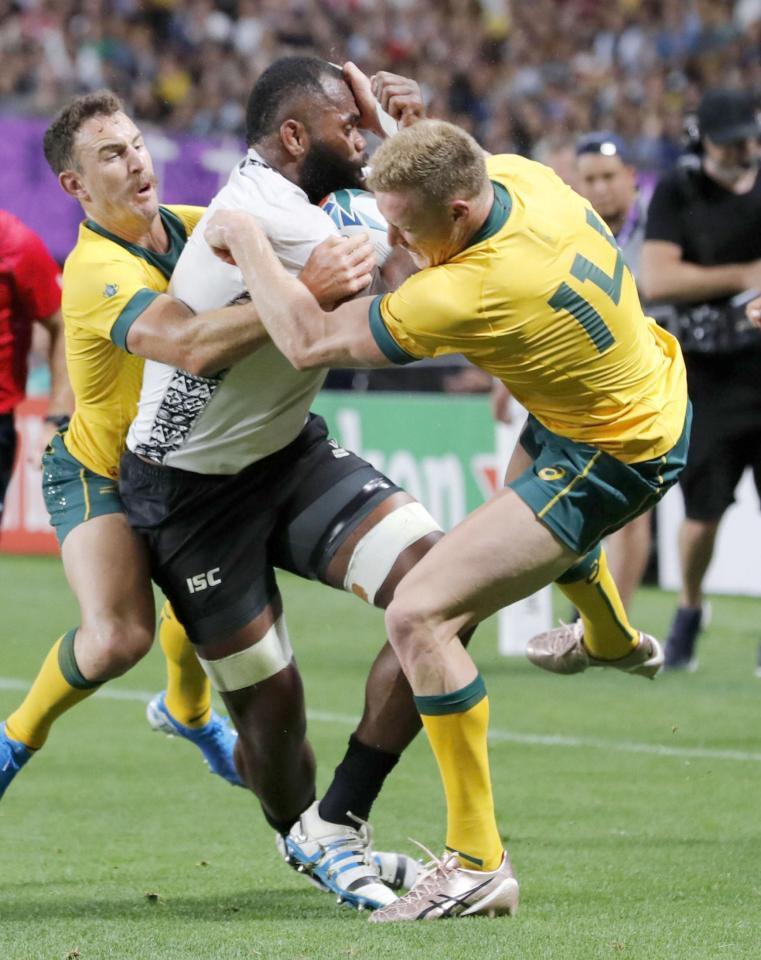 　21日のフィジー戦の前半、ヤト（中央）にタックルするオーストラリアのホッジ（右）。危険度の高い反則行為とされた＝札幌ドーム