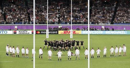 　試合前のニュージーランドのハカ（中央）に対し、逆三角形の「くの字」の陣形を敷くイングランド代表＝２６日、日産スタジアム