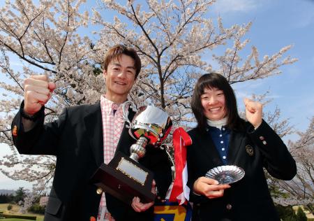 　優勝カップを手に笑顔を見せる男子部門優勝の尾崎竜二（左）と女子部門優勝の阿部実里（撮影・飯室逸平）