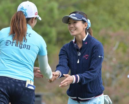 　通算４アンダーの単独首位でホールアウトし同組の笠りつ子（左）と握手をする藤田光里