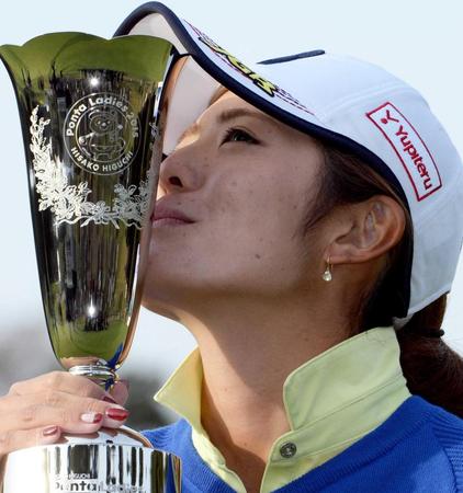 　通算１１アンダーで優勝し、トロフィーにキスをする渡辺彩香