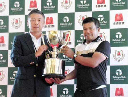 　韓裕・大会最高顧問（左）から優勝カップを受け取ったマークセン