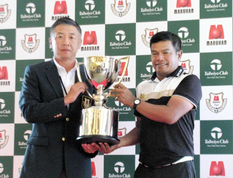 　韓裕・大会最高顧問（左）から優勝カップを受け取ったマークセン