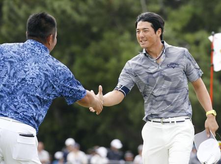 　第３日、ホールアウトし、２位の小田龍一（左）と握手する首位の石川遼＝芥屋ＧＣ