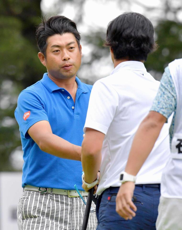 　ホールアウトし、３位の石川遼（右）と握手を交わす２位の池田勇太（共同）