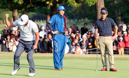 　プレーオフを制しガッツポーズで喜ぶ谷原秀人（左）。右は池田勇太　（共同）