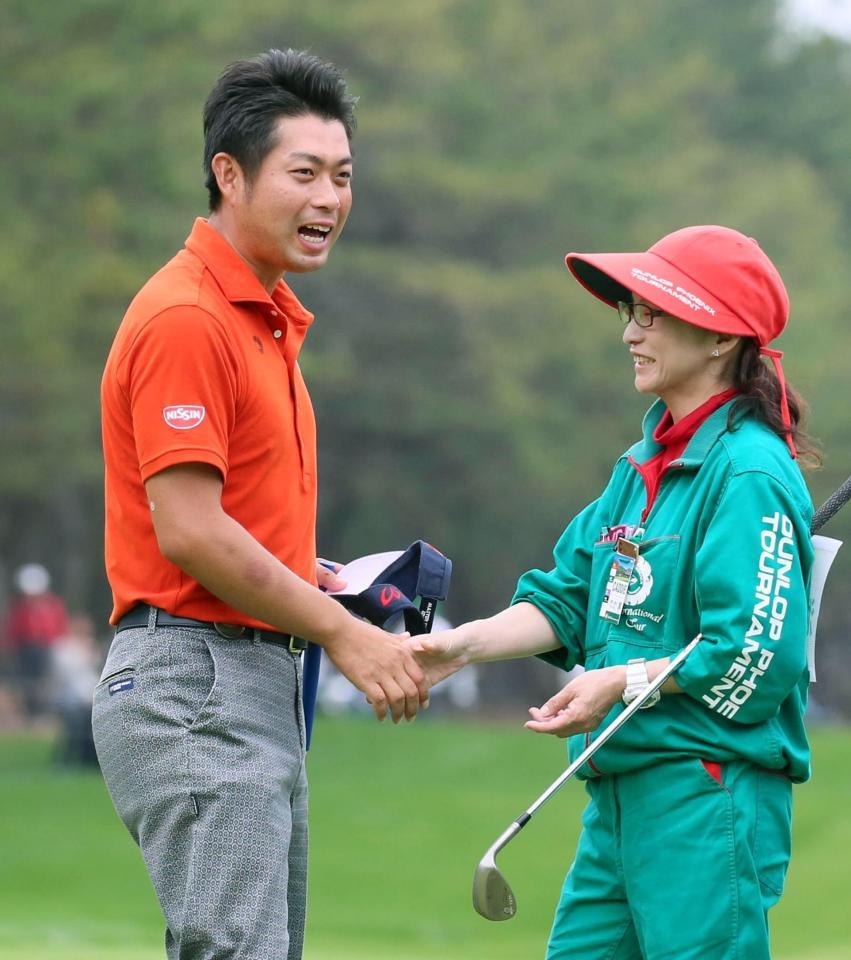 最終日、通算２０アンダーの２位で終えた池田（左）は、キャディーと握手を交わす