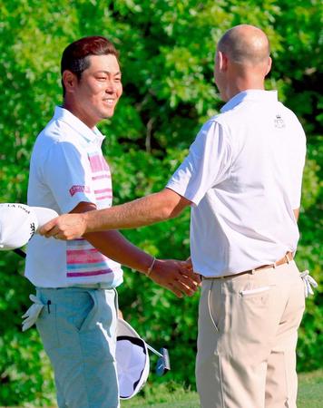 　決勝トーナメント３位決定戦でビル・ハース（右）に敗れ、握手を交わす谷原秀人（共同）