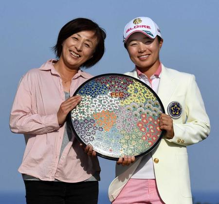 　母親の香奈子さん（左）と優勝杯を手に笑顔