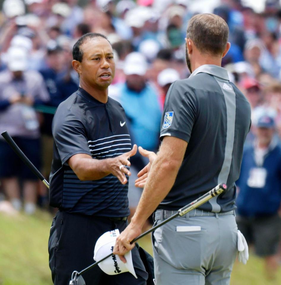 第２ラウンド、ホールアウトし、ダスティン・ジョンソン（右）と握手を交わすタイガー・ウッズ。通算10オーバーで予選落ちした＝シネコックヒルズＧＣ（共同）