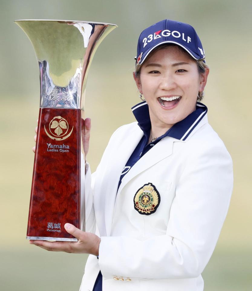 　通算５アンダーで逆転優勝し、カップを手に笑顔の成田美寿々