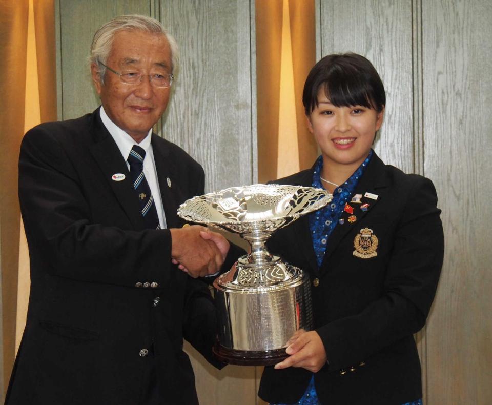 　竹田恒正日本ゴルフ協会長（左）から優勝杯を受け取る西郷真央