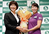　会見でＬＰＧＡの小林浩美会長（左）から花束を受け取り笑顔の渋野日向子（撮影・開出牧）