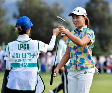 　１３番、イーグルで終えて、キャディーとグータッチを交わす渋野日向子（左）＝小樽ＣＣ（撮影・西岡正）