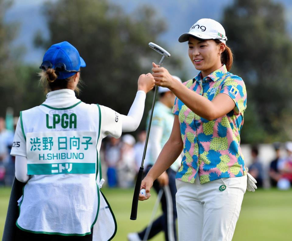 　１３番、イーグルで終えて、キャディーとグータッチを交わす渋野日向子（左）＝小樽ＣＣ（撮影・西岡正）