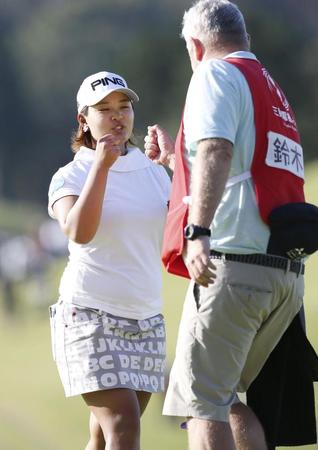 　第１日、ホールアウトし、キャディーとタッチを交わす鈴木愛。６アンダーで首位＝武蔵丘コース
