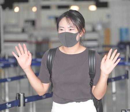 　出国前、報道関係者らに手を振る河本結