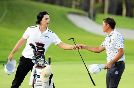 　６位タイに急浮上した石川遼。同組の今平周吾（右）とグータッチを交わす（代表撮影）