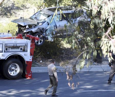２月、米ロサンゼルス近郊で事故を起こして大破し、つり上げられるウッズ選手の車（ロイター＝共同）
