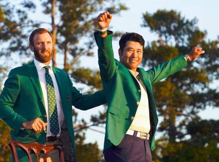 　米ゴルフのマスターズ・トーナメントで日本男子初のメジャー制覇を果たし、グリーンジャケットを着て喜ぶ松山英樹。左は前年優勝のダスティン・ジョンソン＝１１日、米ジョージア州のオーガスタ・ナショナルＧＣ（ＡＰ＝共同）