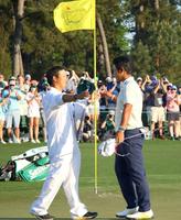 米ゴルフのマスターズ・トーナメントで、日本男子初のメジャー制覇を果たし、キャディー（左）と喜ぶ松山英樹＝11日、米ジョージア州のオーガスタ・ナショナルＧＣ（共同）