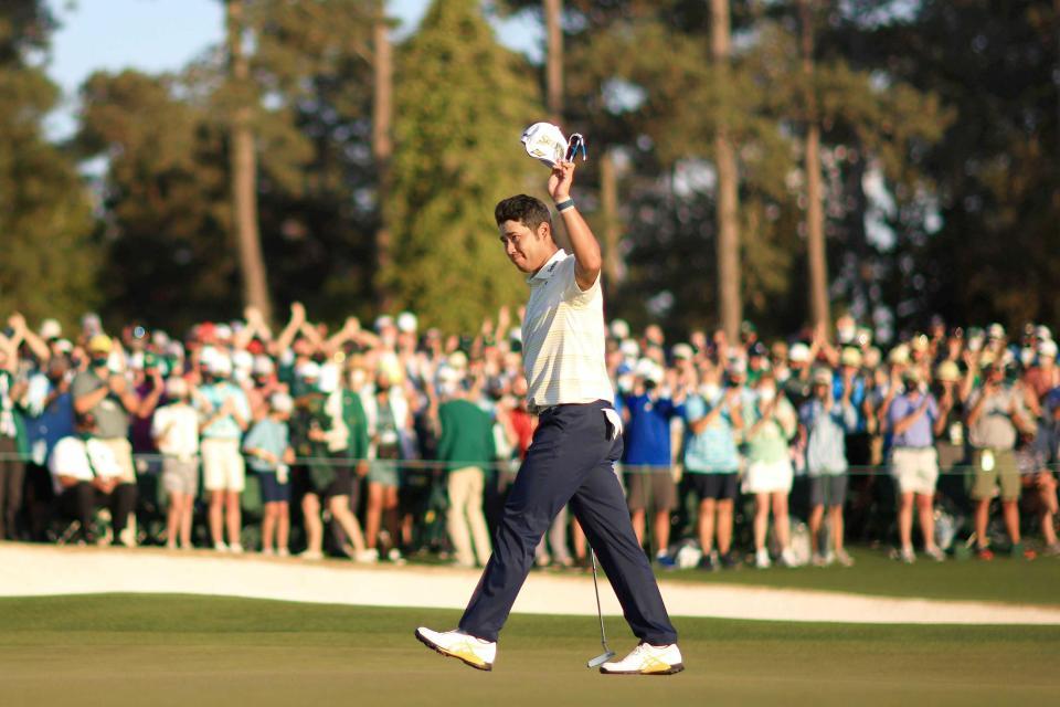 　日本人初のマスターズ優勝を飾り、パトロンの拍手に手を挙げて応える松山英樹（ゲッティ＝共同）