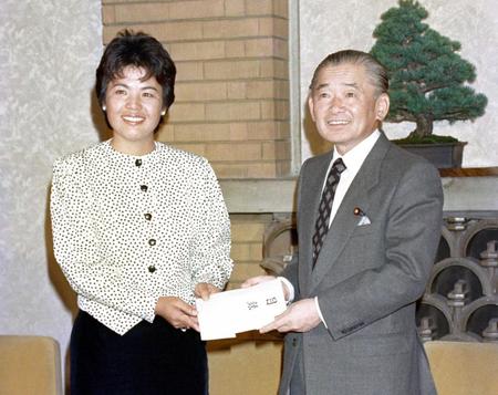 　岡本綾子（左）に内閣総理大臣顕彰の目録を手渡す竹下首相＝１９８７年