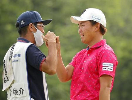 　優勝を決めキャディーとタッチを交わす木下稜介（右）