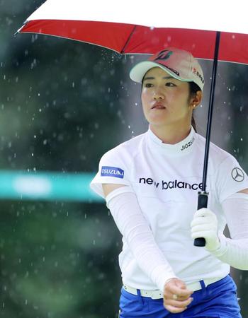 １２番、雨が降りだし、傘を差しながら移動する稲見萌寧（代表撮影）