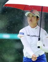 １２番、雨が降りだし、傘を差しながら移動する稲見萌寧（代表撮影）