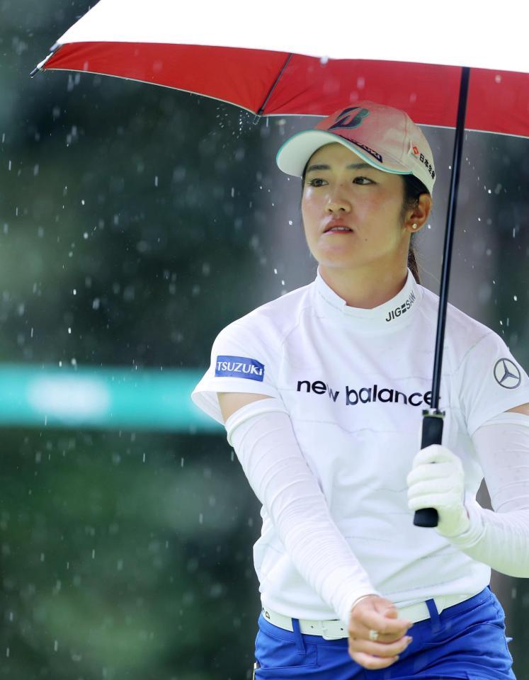 １２番、雨が降りだし、傘を差しながら移動する稲見萌寧（代表撮影）