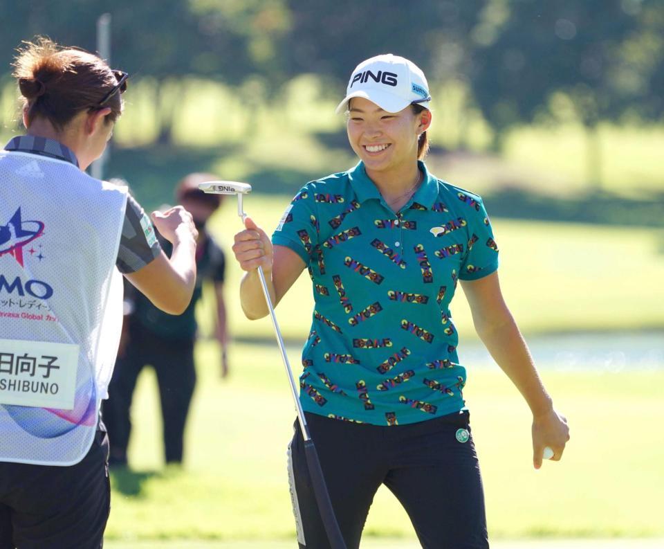 　初日を終え、キャディー（左）とグータッチを交わす渋野日向子（撮影・開出牧）