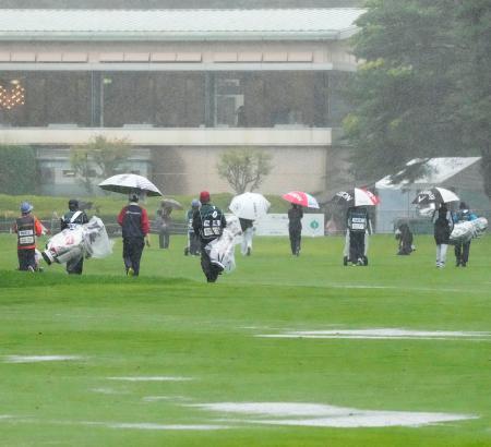 　第２日、激しい雨のためラウンドが中断し、クラブハウスへ引き揚げる選手ら＝軽井沢７２