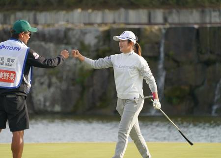 １８番、ウイニングパットを決めキャディー（左）とグータッチを交わす稲見萌寧＝千葉・グレートアイランド倶楽部（撮影・開出牧）