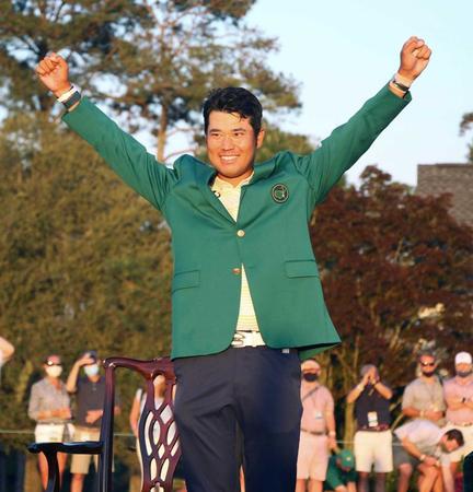 　米ゴルフのマスターズ・トーナメントで、日本男子初のメジャー制覇を果たし、グリーンジャケットを着て両手を上げる（共同）