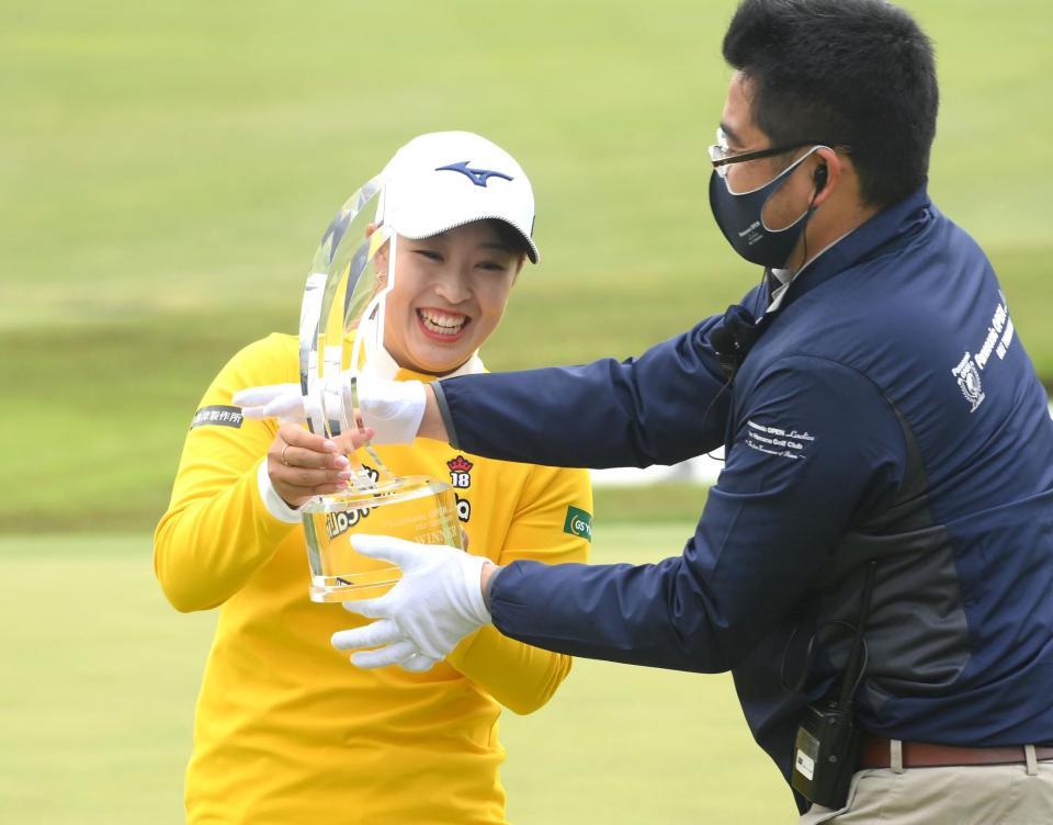 　優勝トロフィーの重さに苦笑する西郷真央（撮影・堀内翔）