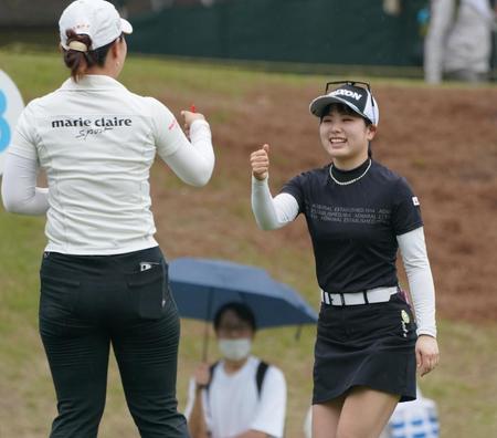 　ホールアウトし笑顔で黄アルムとタッチを交わす尾関彩美悠（撮影・神子素慎一）