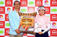 ホールインワン賞の商品券５万円と副賞のシャウエッセンを贈られた西村優菜＝北海道苫小牧市・桂ＧＣ（大会提供）