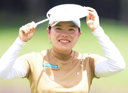 うちわで日差しを防ぎながら、プロアマ戦のラウンドをする勝みなみ