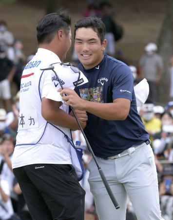 　通算１６アンダーでツアー初優勝を果たし、キャディーと抱き合う河本力（右）＝芥屋ＧＣ