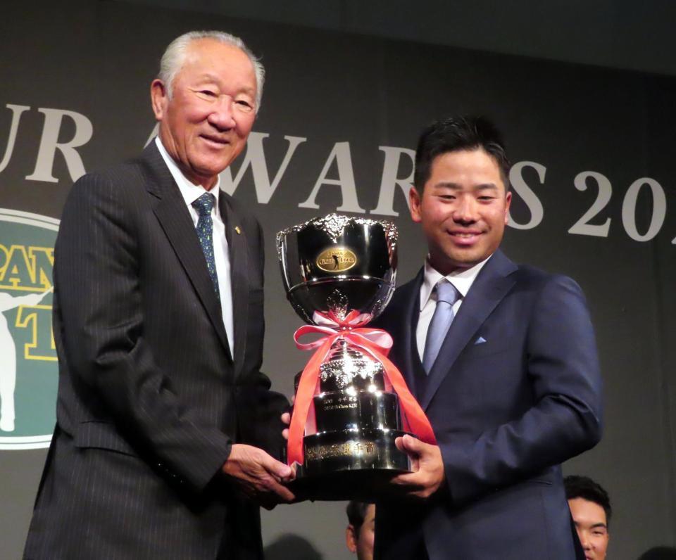 ＪＧＴＯ青木功会長からトロフィーを受け取る比嘉一貴＝東京都内のホテル