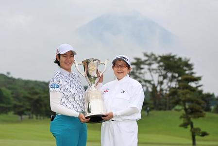 　富士山を背景に、キャディーを務めた母親の麻子さん（右）と優勝カップを手に笑顔を見せる川岸史果