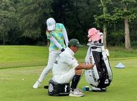 キャディーが座ったサンドバッグを打つ稲見