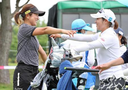 　５アンダーでホールアウトし、同組の浜田茉優とハグする藤本麻子（左）