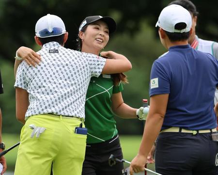 　プレーオフ１ホール目、優勝を決め岩井明（左）と申ジエ（右）に祝福され笑顔の菊地絵理香