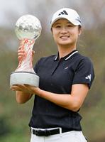 　通算13アンダーで優勝し、トロフィーを掲げる森田遥