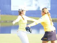 　優勝争いをした同組の桑木志帆（右）と抱き合う稲見萌寧（撮影・開出牧）