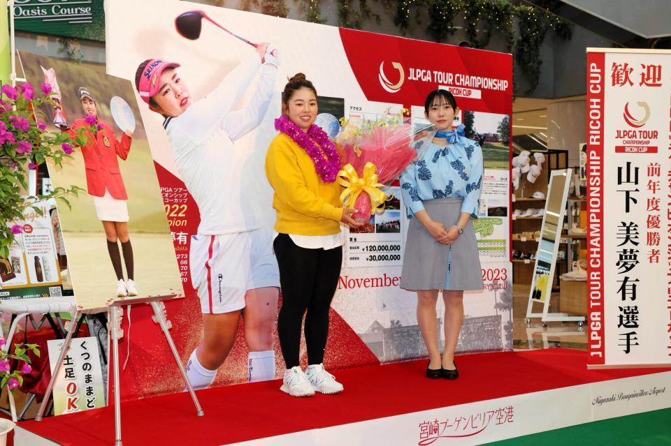 　宮崎空港の歓迎セレモニーで花束を受け取る山下（左）